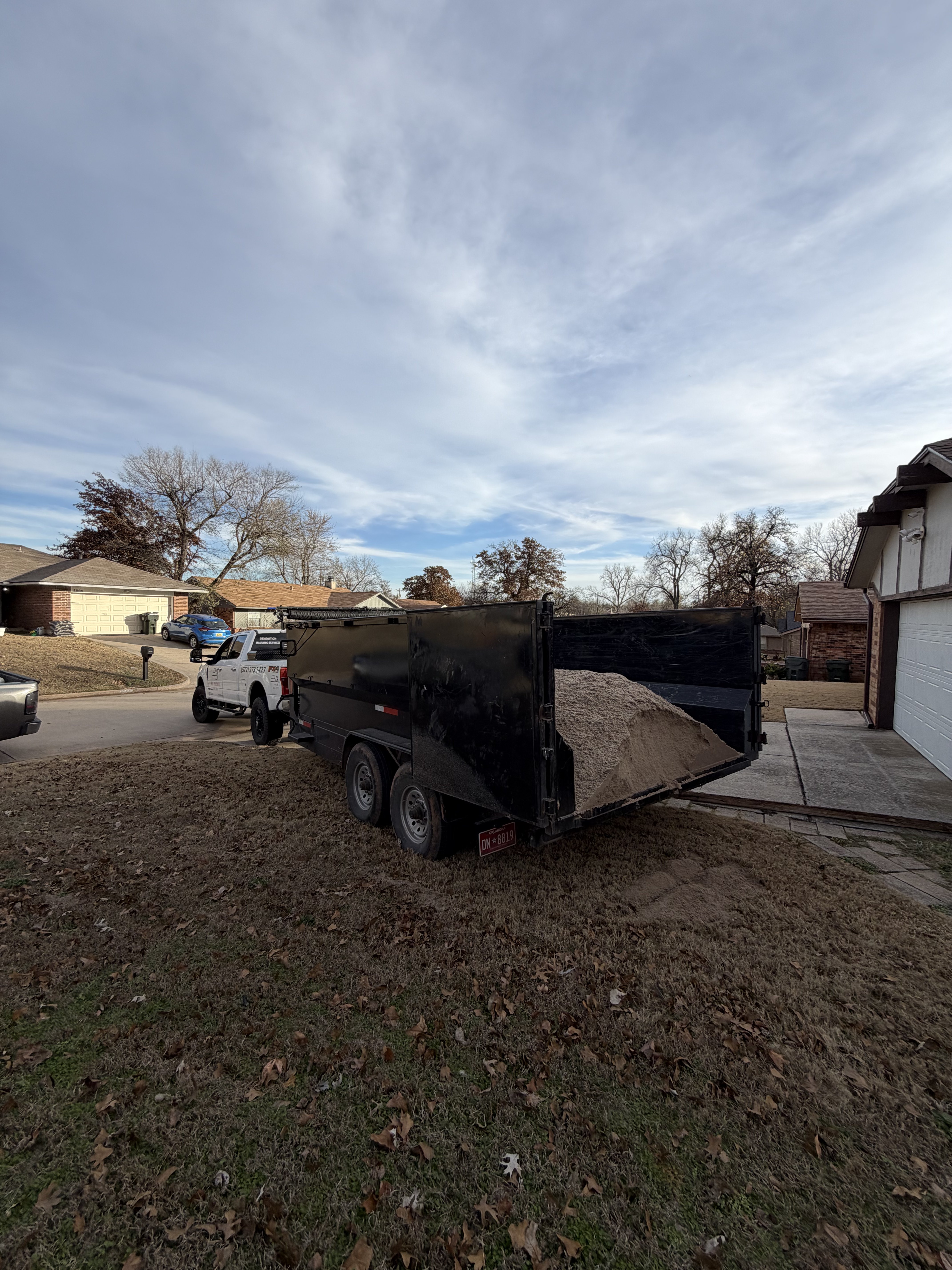 Appliance hauling and junk removal serviceBig Trucking LLC dump trailer unloading gravel for landscaping in Oklahoma City residential driveway